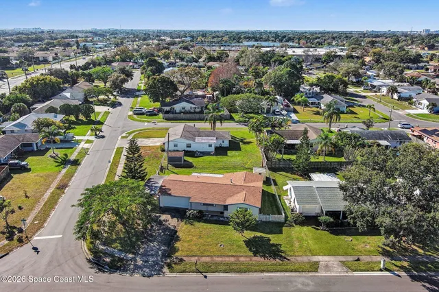 an aerial view of residential houses with outdoor space and swimming pool