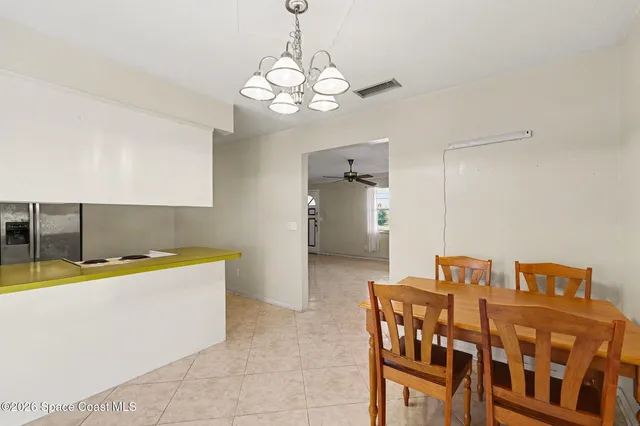 a room with a table chairs and chandelier