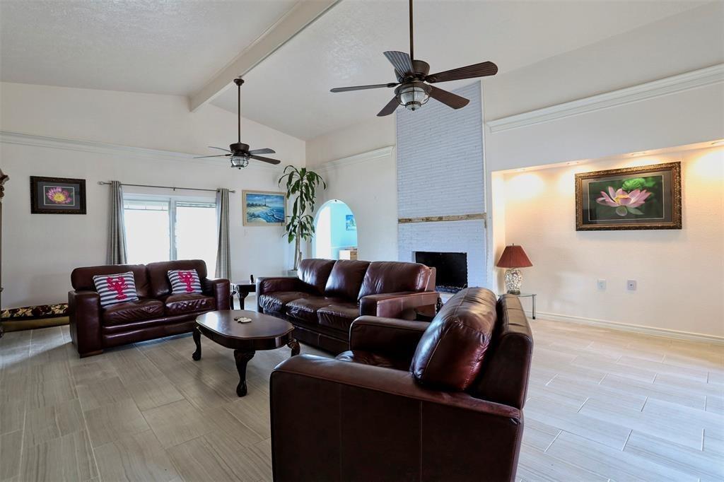 a living room with furniture a ceiling fan and a window