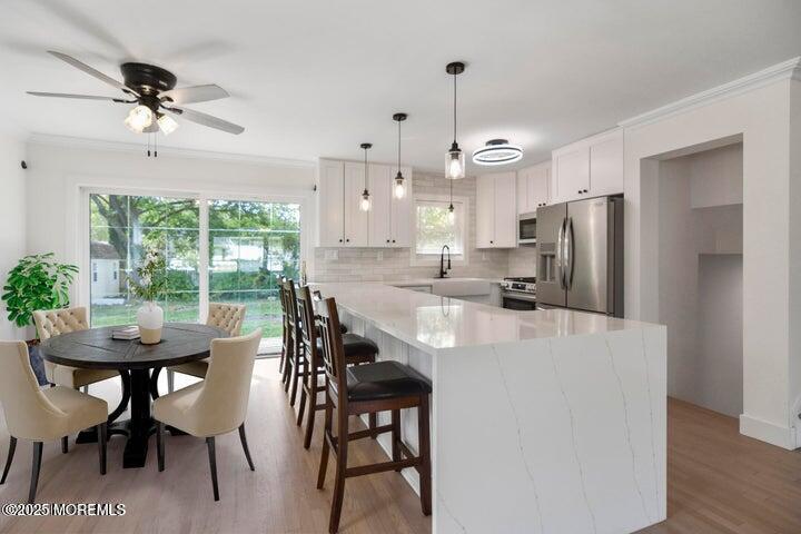 7 Kaylen Place Hazlet, NJ 07730 - Photo 12 of 22 a kitchen with stainless steel appliances a table chairs and a refrigerator