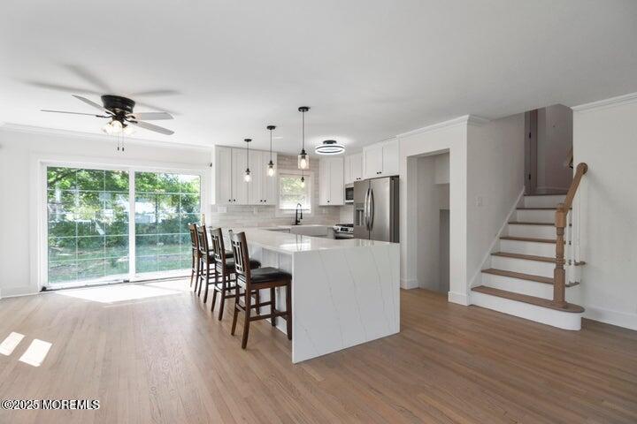 7 Kaylen Place Hazlet, NJ 07730 - Photo 7 of 22 a kitchen with stainless steel appliances a dining table chairs and wooden floor