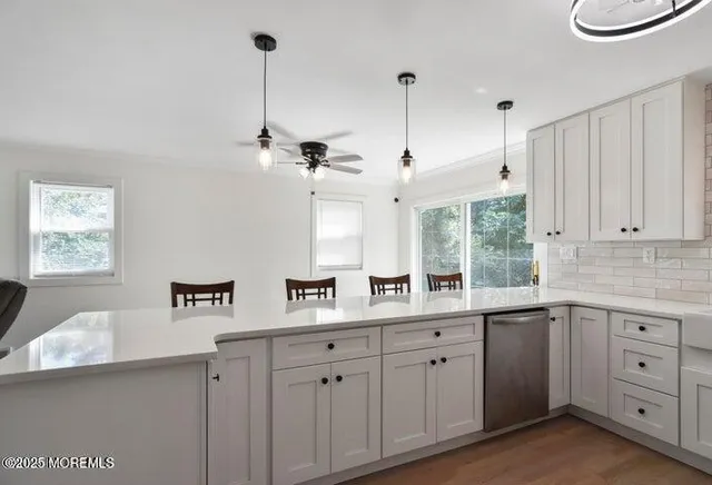 a kitchen with white cabinets and window