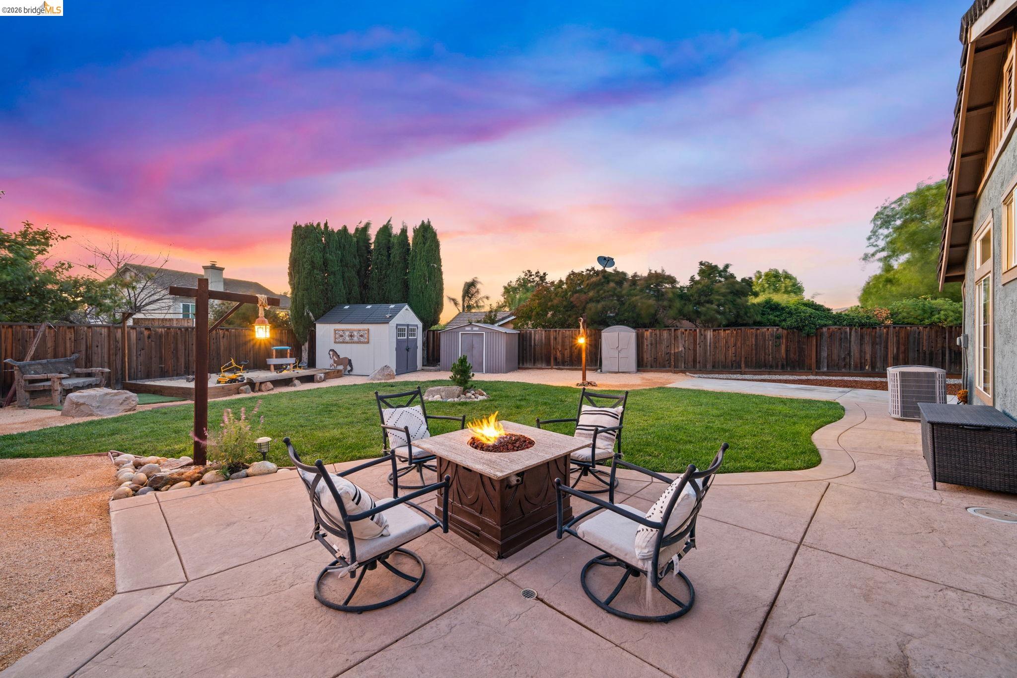 1186 El Rio Court Livermore, CA 94551 - Photo 33 of 60 Expansive backyard featuring a concrete patio, a stone fire pit, and a lush lawn