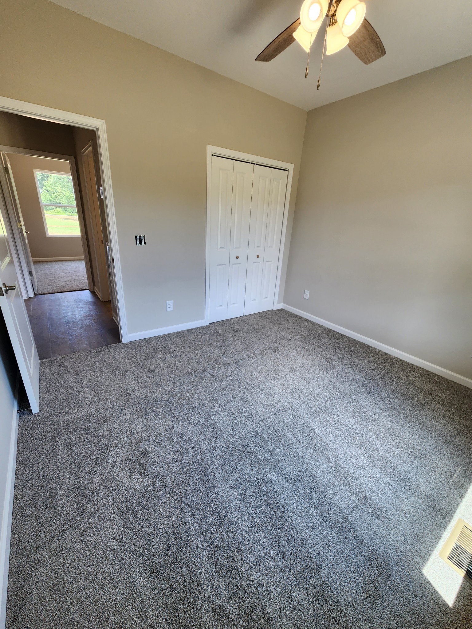 7687 Covington Road White House, TN 37188 - Photo 13 of 16 an empty room with a chandelier fan and windows