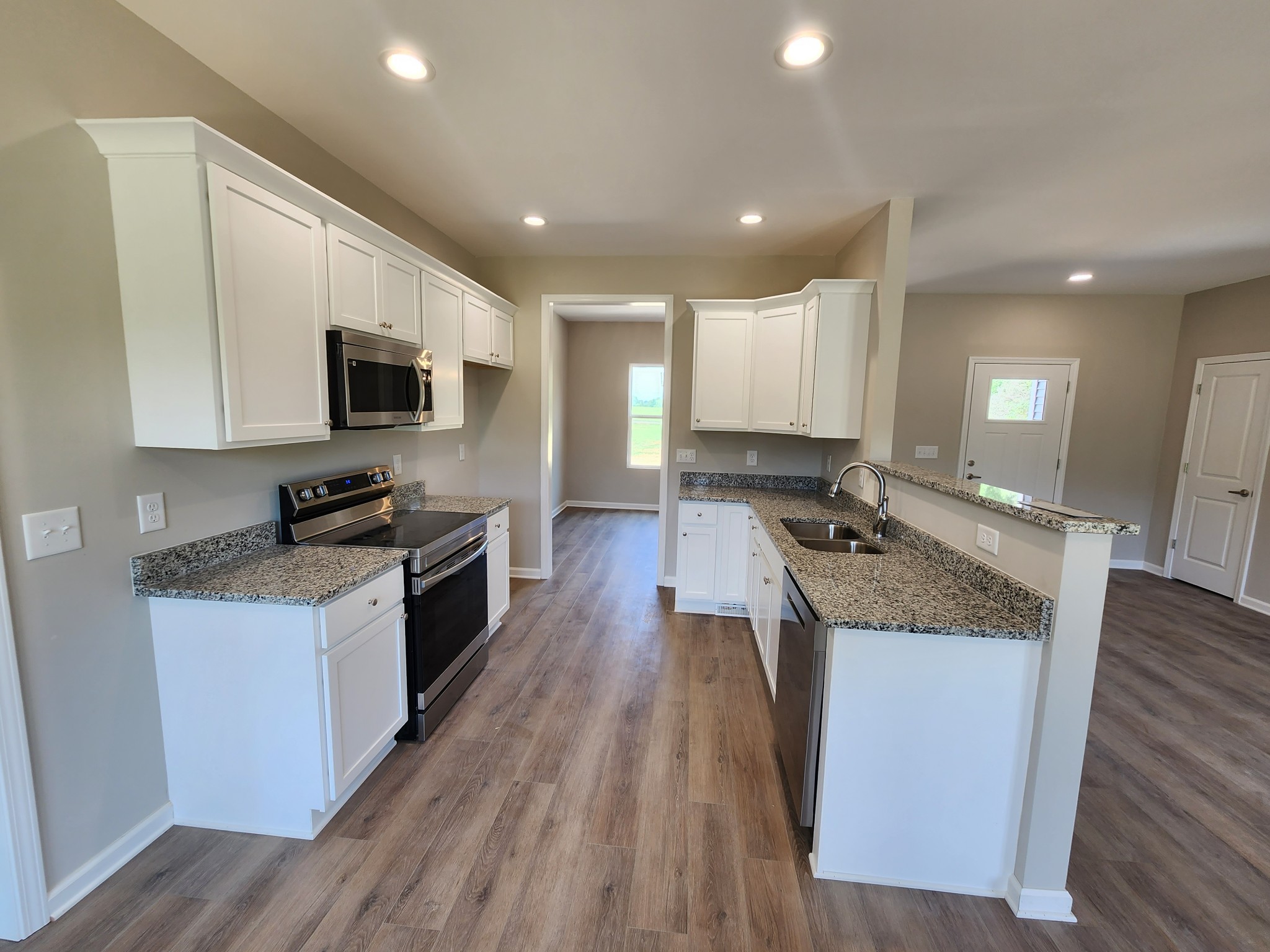 7687 Covington Road White House, TN 37188 - Photo 7 of 16 a large kitchen with stainless steel appliances granite countertop a stove a sink and a microwave