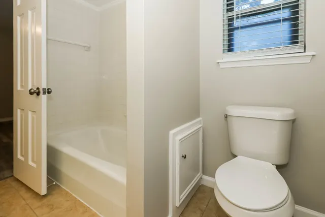 a white toilet sitting next to a bath tub
