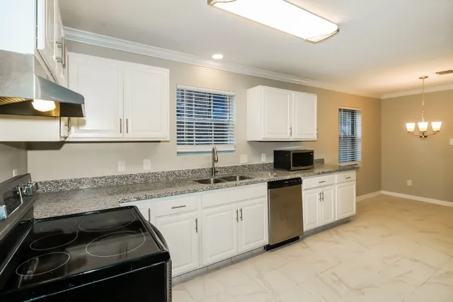 a kitchen with granite countertop white cabinets and white appliances
