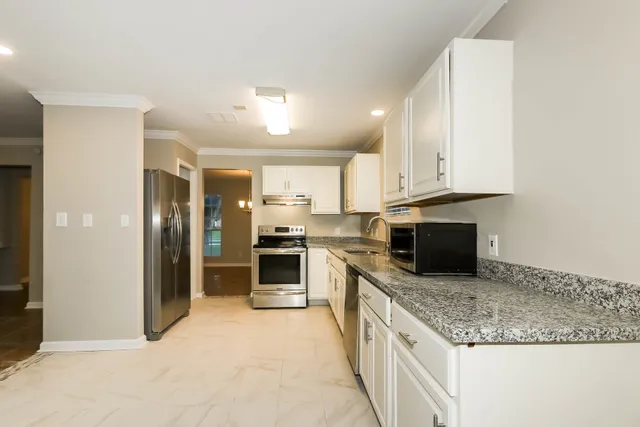 a kitchen with stainless steel appliances granite countertop a stove oven and a refrigerator