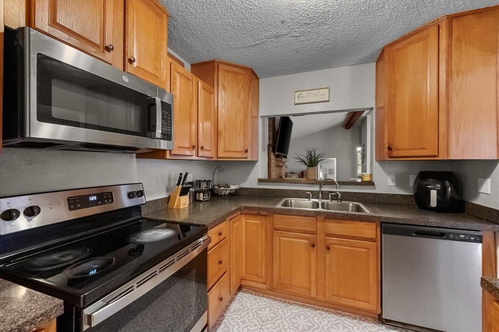 1312 Hackamore Street Mesquite, TX 75149 - Photo 11 of 28 a kitchen with a stove a sink and a microwave