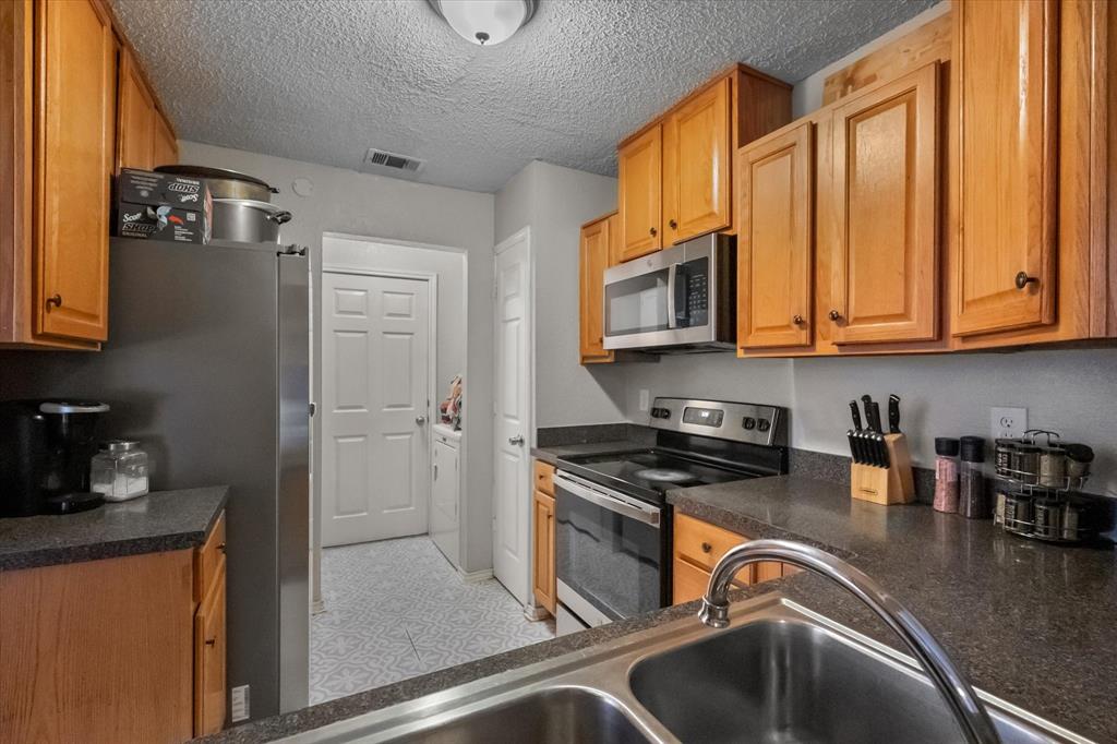 1312 Hackamore Street Mesquite, TX 75149 - Photo 13 of 28 a kitchen with stainless steel appliances granite countertop a sink a refrigerator and a stove