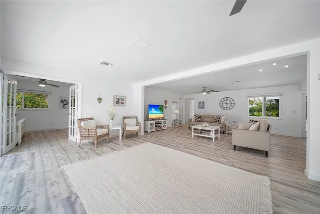 a bedroom with a large bed and a chandelier fan