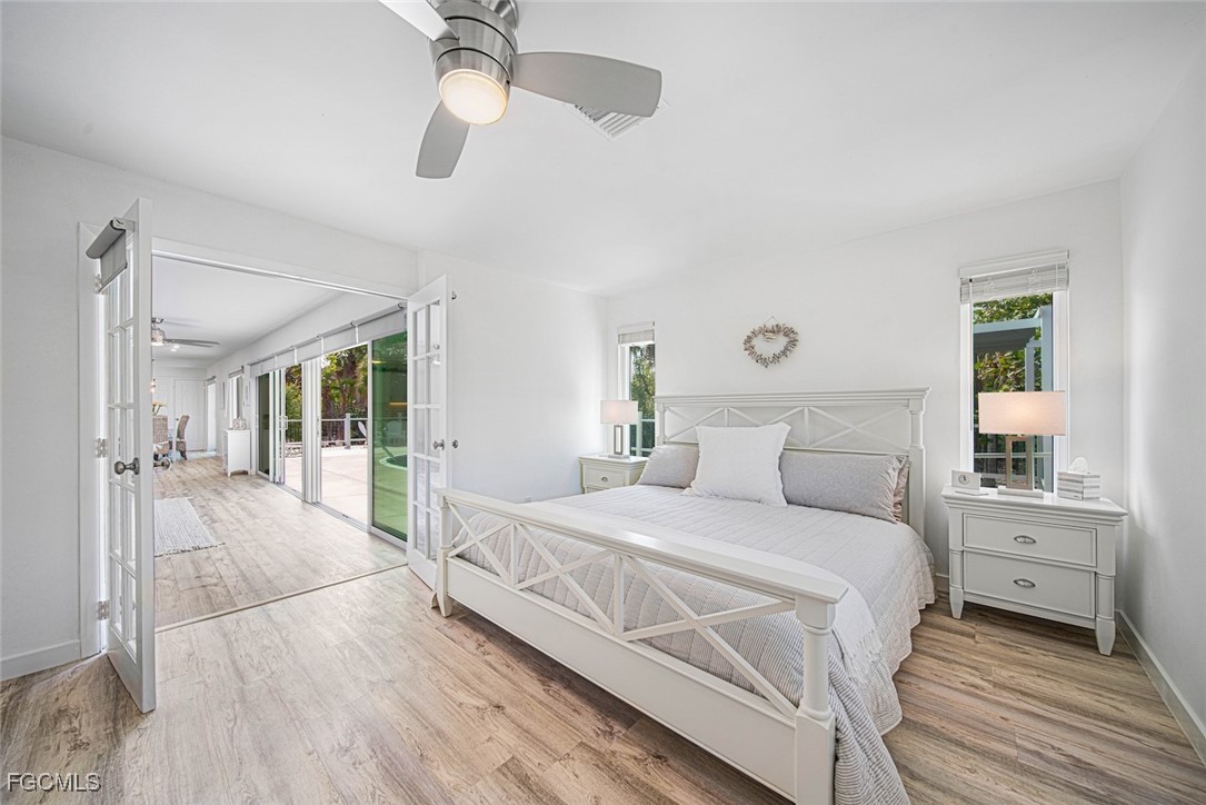 4639 Brainard Bayou Road Sanibel, FL 33957 - Photo 24 of 50 a bedroom with a large bed and a chandelier fan