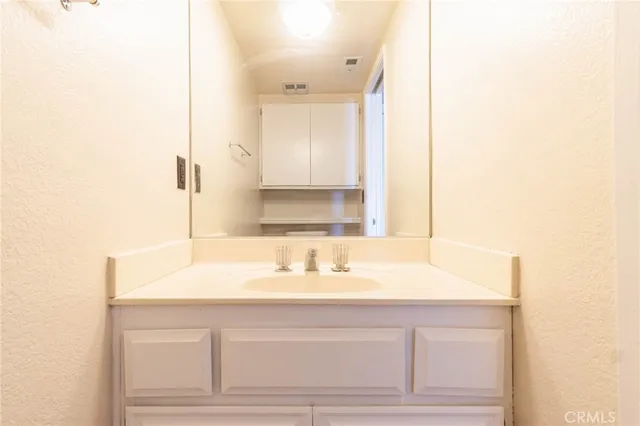 an empty room with chandelier fan and windows