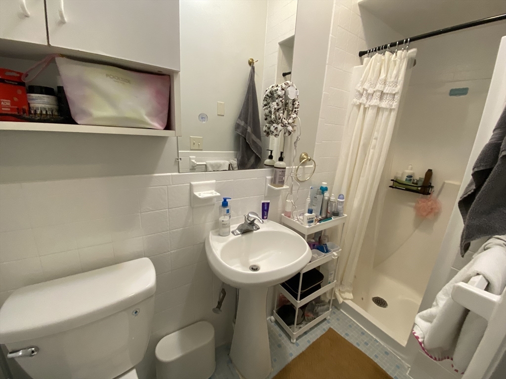 5 Battery Street, Unit 2F Boston, MA 02109 - Photo 14 of 15 a bathroom with a sink toilet and shower