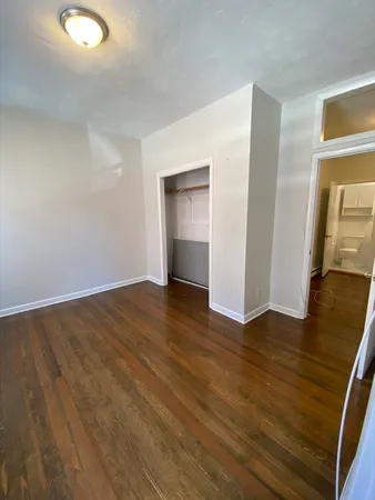 an empty room with wooden floor and closet