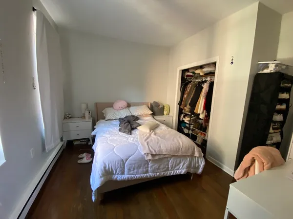 a bedroom with a bed wooden floor and a table