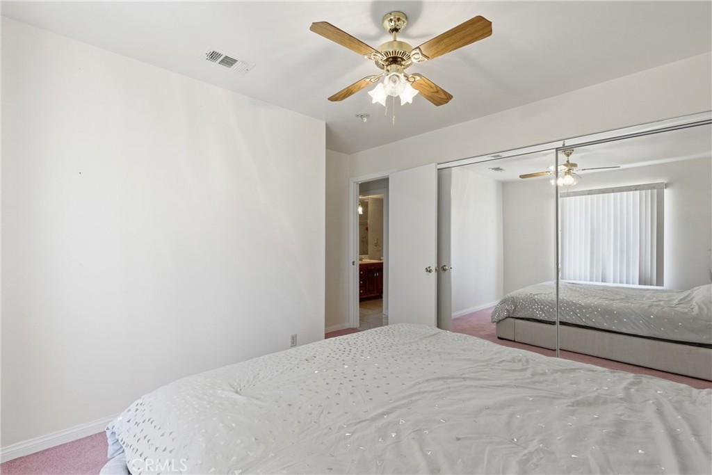 14455 Summit Valley Road Hesperia, CA 92345 - Photo 11 of 26 a bedroom with a large bed and a chandelier