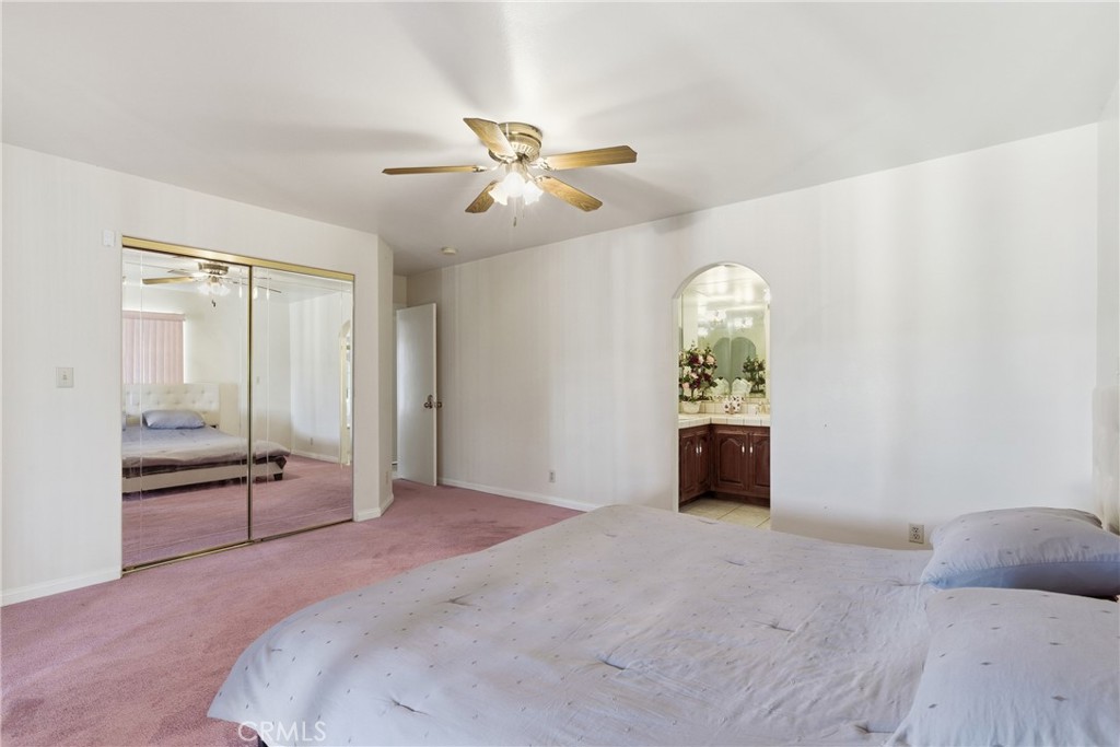 14455 Summit Valley Road Hesperia, CA 92345 - Photo 13 of 26 a bedroom with a bed and a chandelier