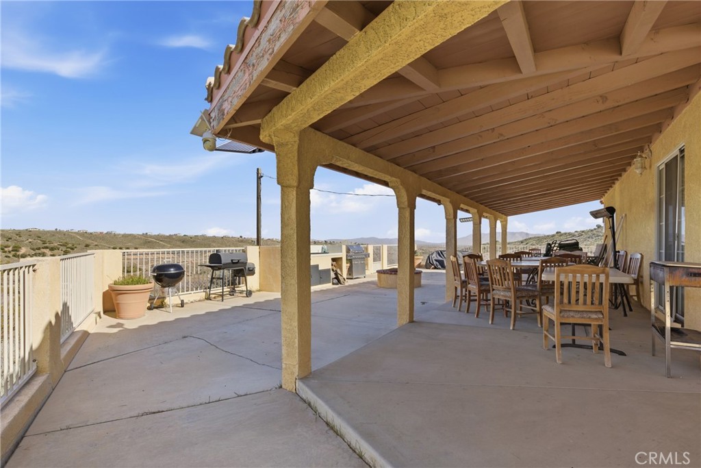 14455 Summit Valley Road Hesperia, CA 92345 - Photo 15 of 26 a view of a patio with a table and chairs and couches with wooden floor