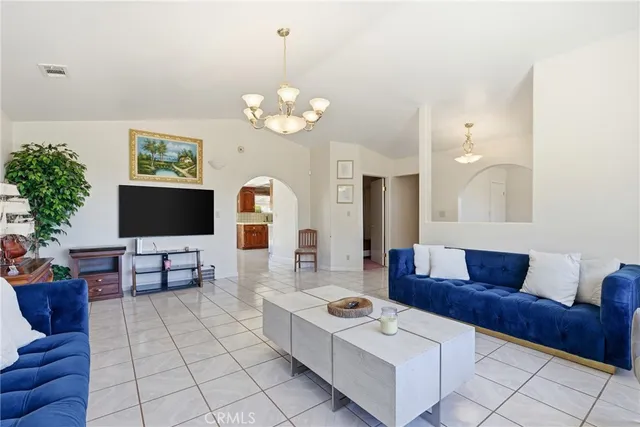 a living room with furniture a chandelier and a flat screen tv