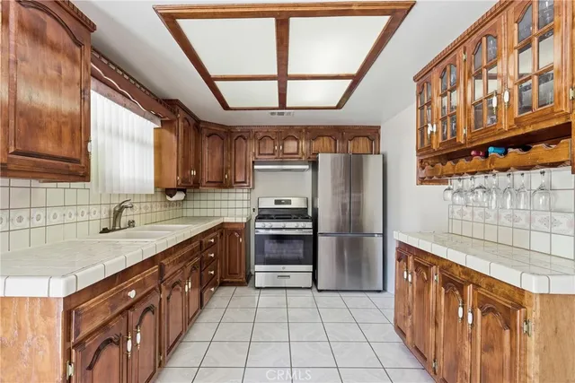 a kitchen with stainless steel appliances granite countertop a refrigerator and a sink