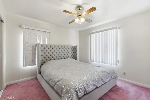 a large bed sitting in a bedroom next to a window and a chandelier