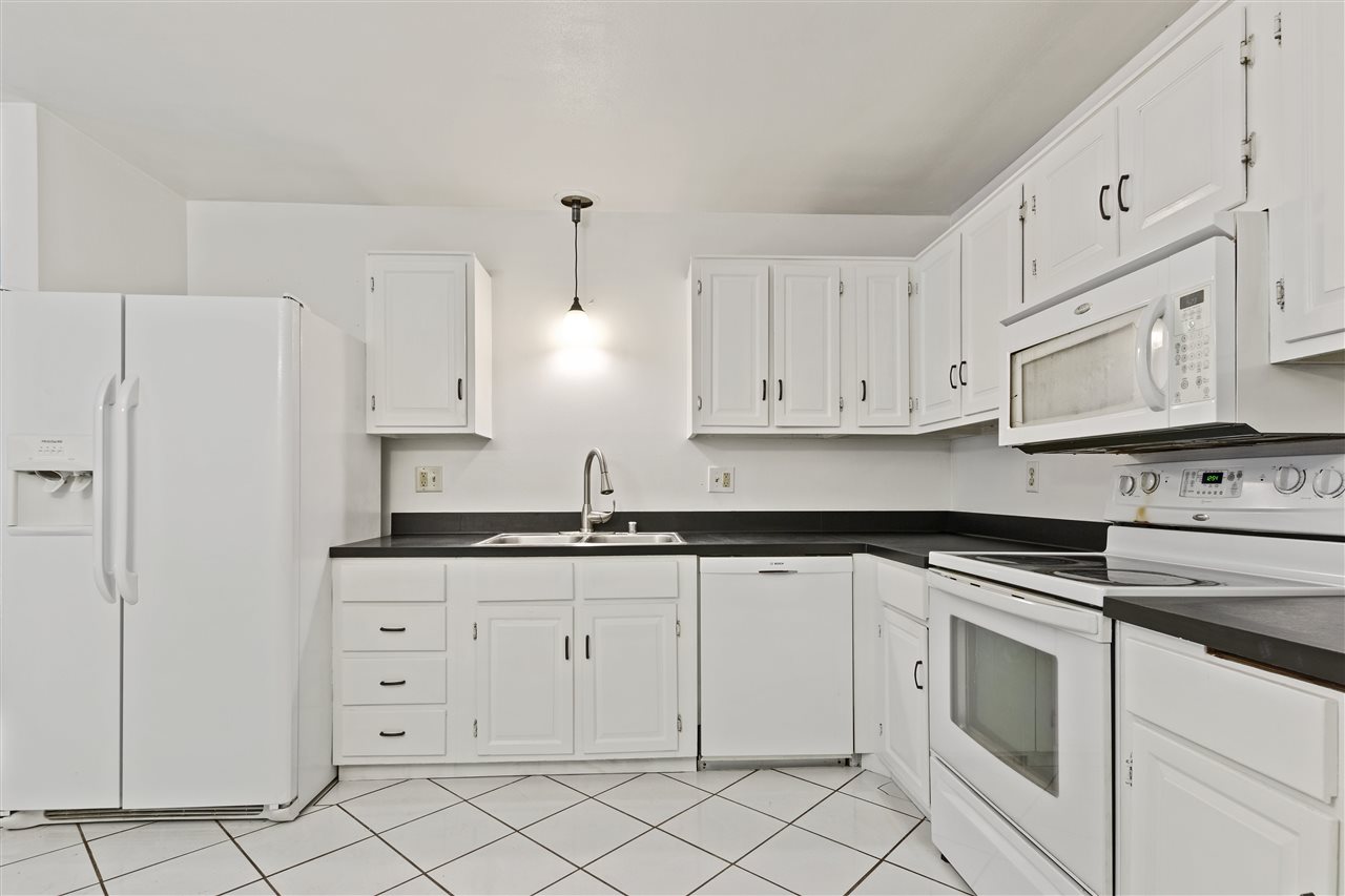 4570 Sunderman Road Rockford, IL 61114 - Photo 7 of 17 a kitchen with white cabinets and white appliances