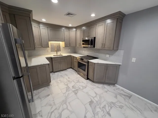 a kitchen with a sink refrigerator and microwave