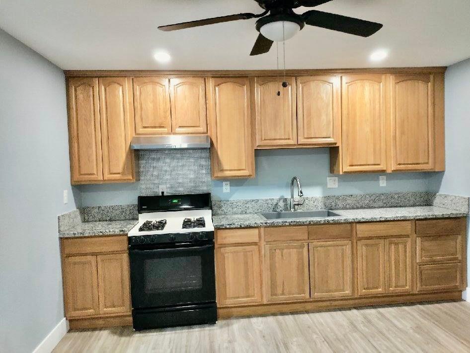 2653 Princeton Street Sacramento, CA 95815 - Photo 8 of 10 a kitchen with stainless steel appliances granite countertop a stove a sink and a microwave