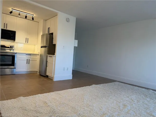 a view of a kitchen with refrigerator stove and wooden floor