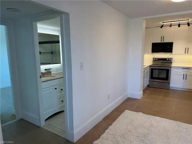 a view of kitchen and empty room with fireplace