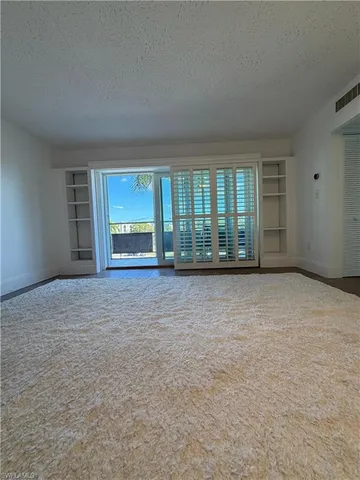 an empty room with a fireplace and large window