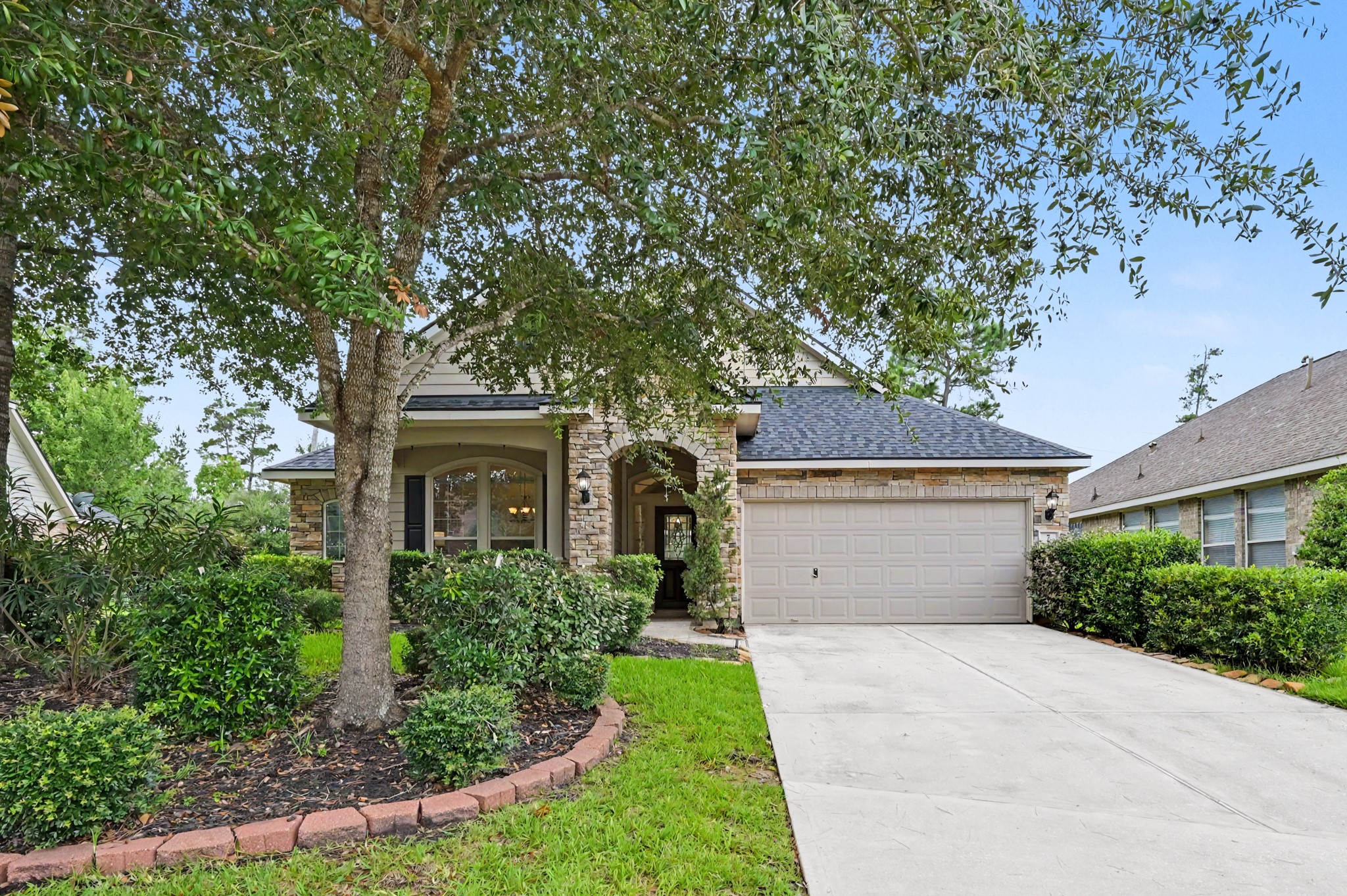7 Fraiser Fir Place Spring, TX 77389 - Photo 3 of 26 front view of a house with a garden
