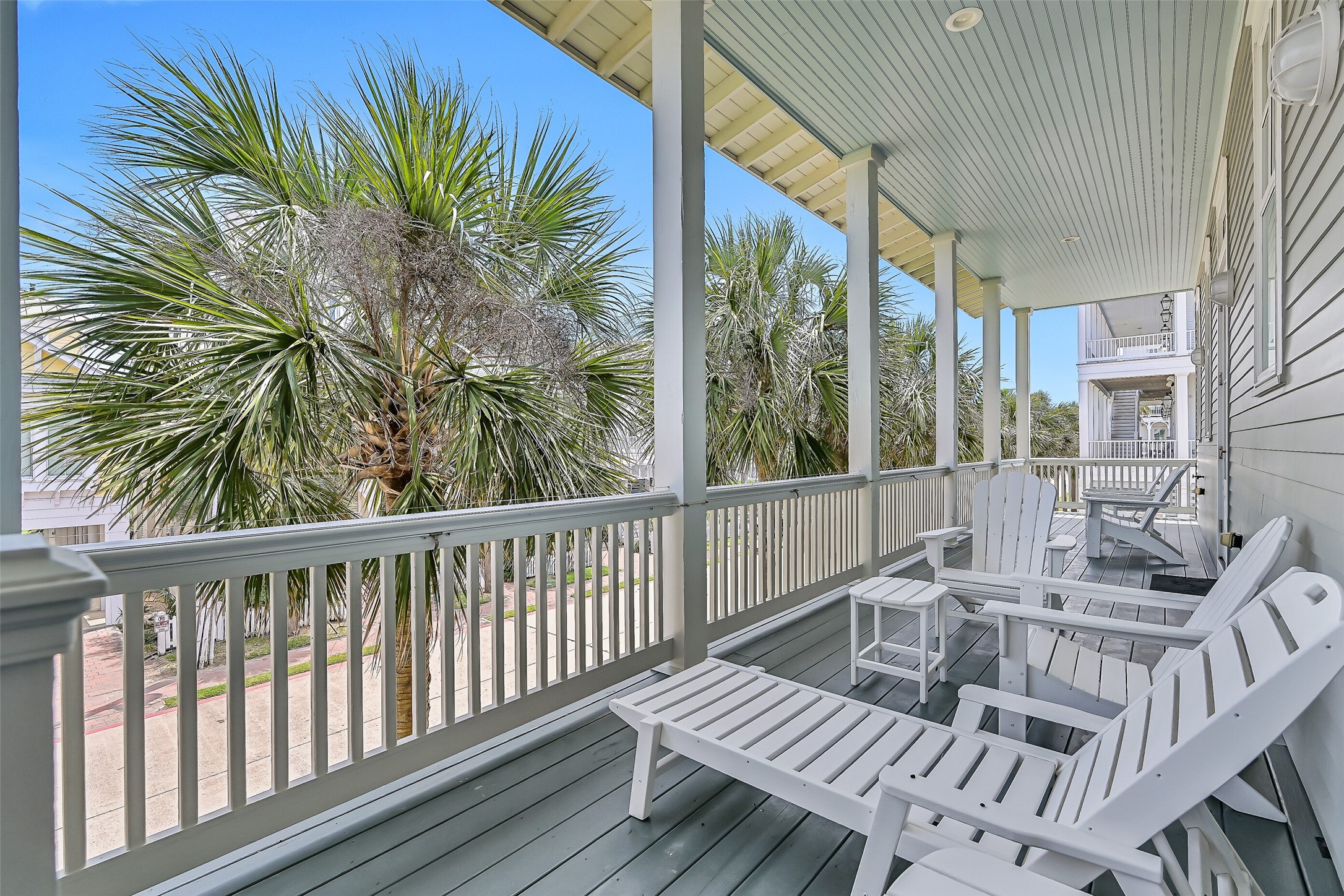 817 Positano Road Galveston, TX 77550 - Photo 43 of 50 Designed for year-round enjoyment, this spacious covered porch offers multiple seating areas and beautiful neighborhood views. It's an ideal setting for embracing the relaxed lifestyle that makes Beachtown so special.