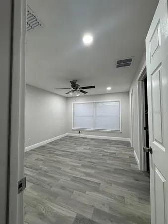 a view of empty room with wooden floor