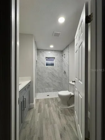 a bathroom with a bathtub shower sink mirror and toilet