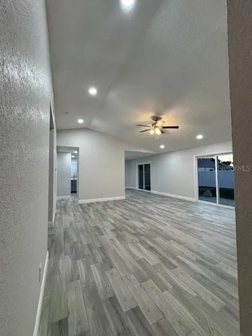 a view of empty room with wooden floor