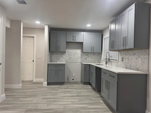 a kitchen with a sink cabinets and wooden floor