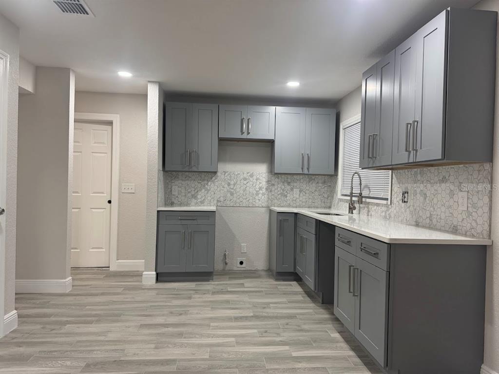 12142 Caper Street Orlando, FL 32837 - Photo 2 of 15 a kitchen with a sink cabinets and wooden floor