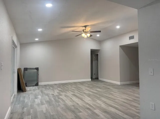 a view of an empty room with a ceiling fan