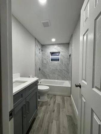 a bathroom with a granite countertop sink toilet and shower