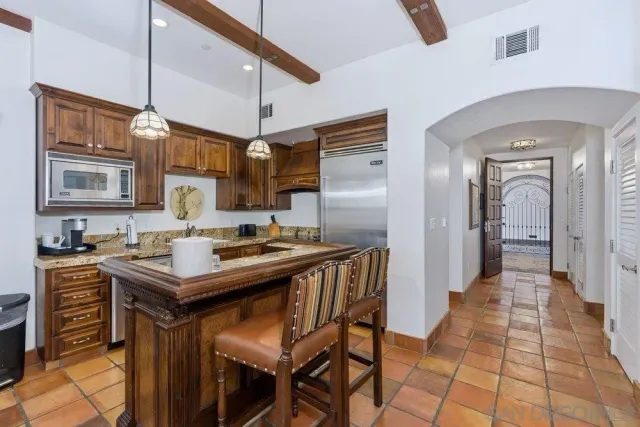 a kitchen with stainless steel appliances granite countertop a sink a stove and a refrigerator
