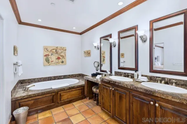 a bathroom with a granite countertop tub sink and mirror