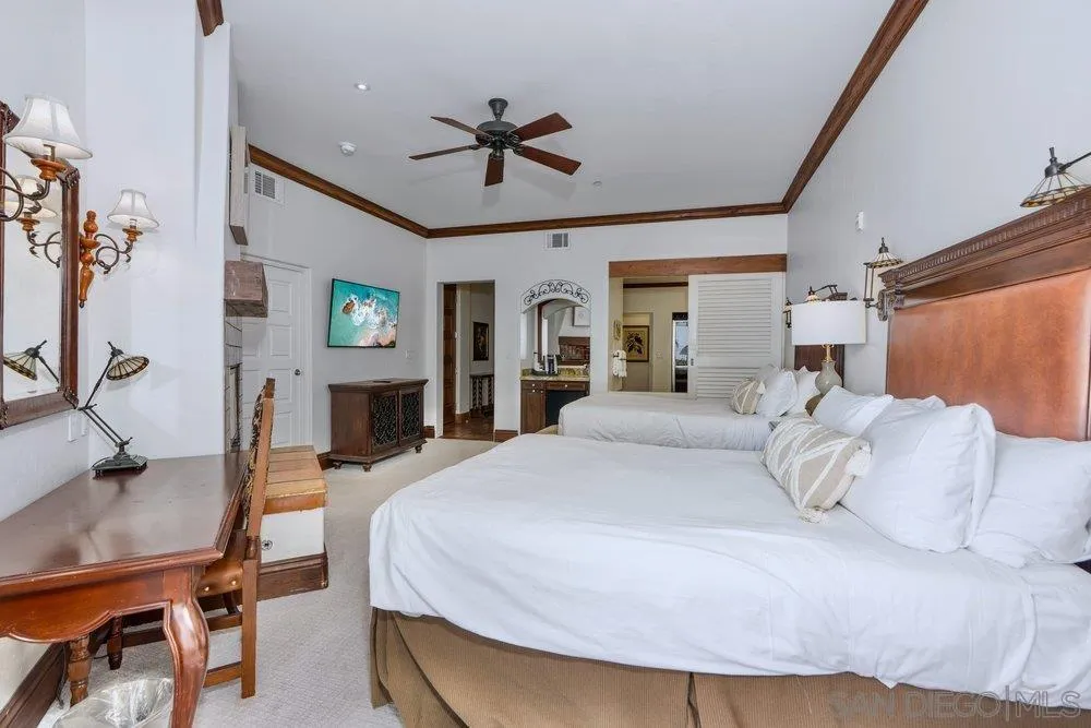 7319 Estrella De Mar Road Carlsbad, CA 92009 - Photo 8 of 13 a bedroom with a large bed and a chandelier