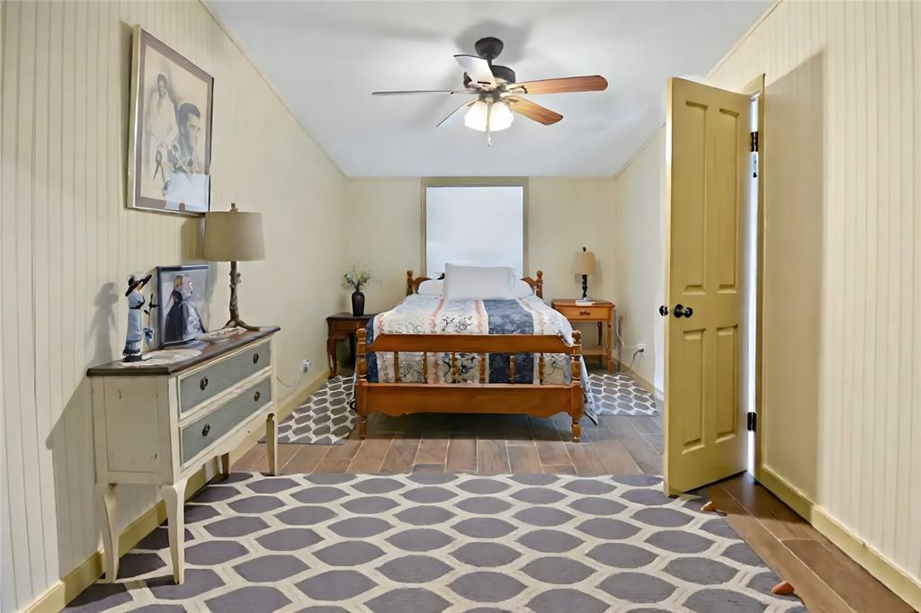 5167 Rockhill Road Aubrey, TX 76227 - Photo 21 of 29 a bedroom with a bed and a chandelier