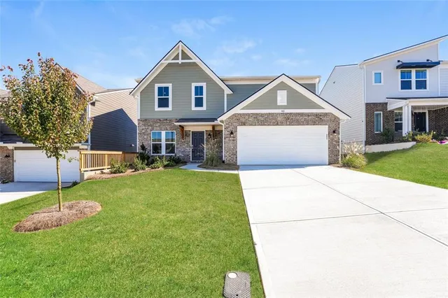 a front view of a house with a yard and garage