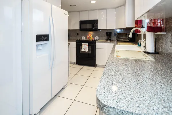 a kitchen with stainless steel appliances granite countertop a sink and a counter top space
