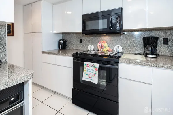 a kitchen with stainless steel appliances granite countertop a sink stove and cabinets