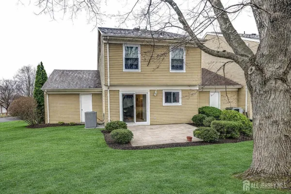 a front view of a house with a yard and potted plants