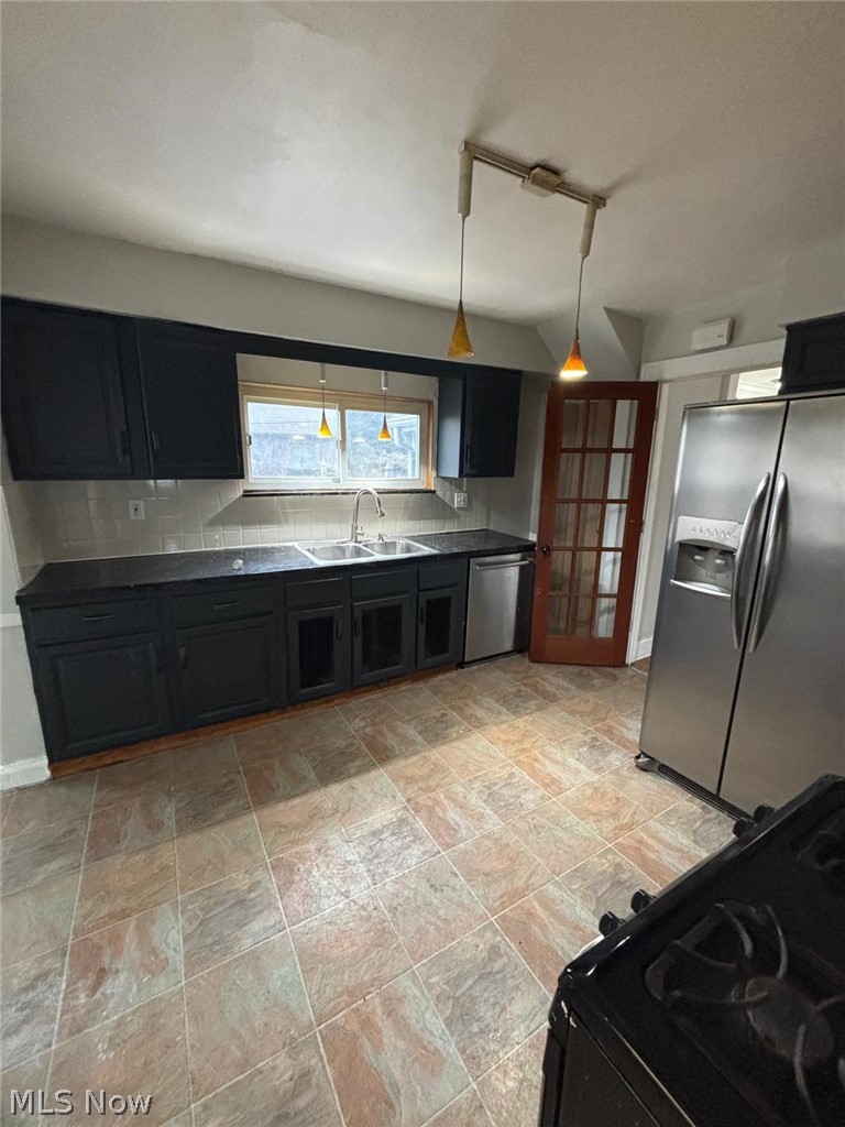 3808 Kirkwood Road Cleveland Heights, OH 44121 - Photo 5 of 6 Kitchen with dark cabinetry, stainless steel appliances, hanging light fixtures, backsplash, and french doors